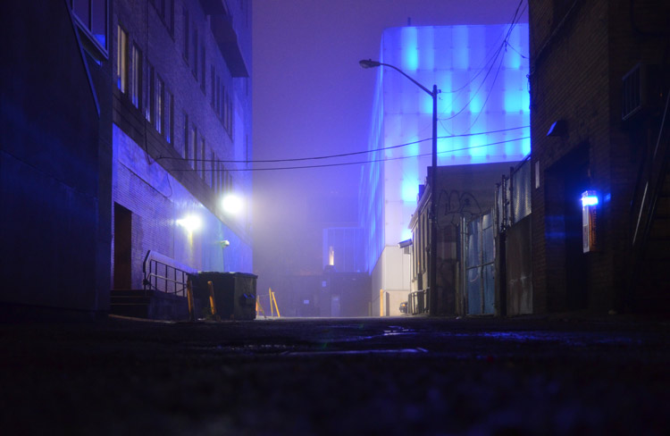 An alley way that is lit with a blue light. 