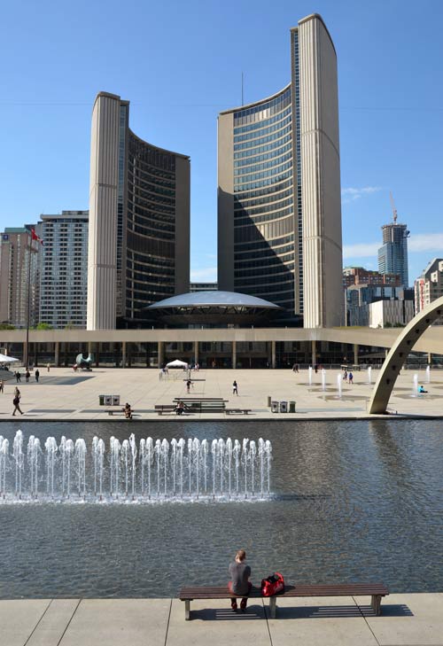 TOronto City Hall in the background with the fountain in Nathan Phillips Square in the foreground