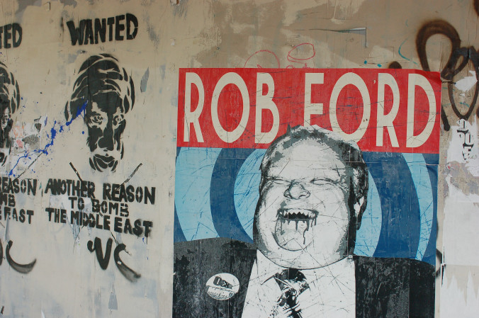 graffiti showing a laughing Rob Ford with bloody fangs.  Beside it is graffiti about the bombing of the Middle East