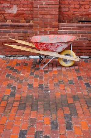 orange wheelbarrow outside one of the brick buildings in the Distillery District