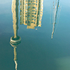 Reflections in the water at harbourfront including boats that are moored there as well as the CN Tower.  