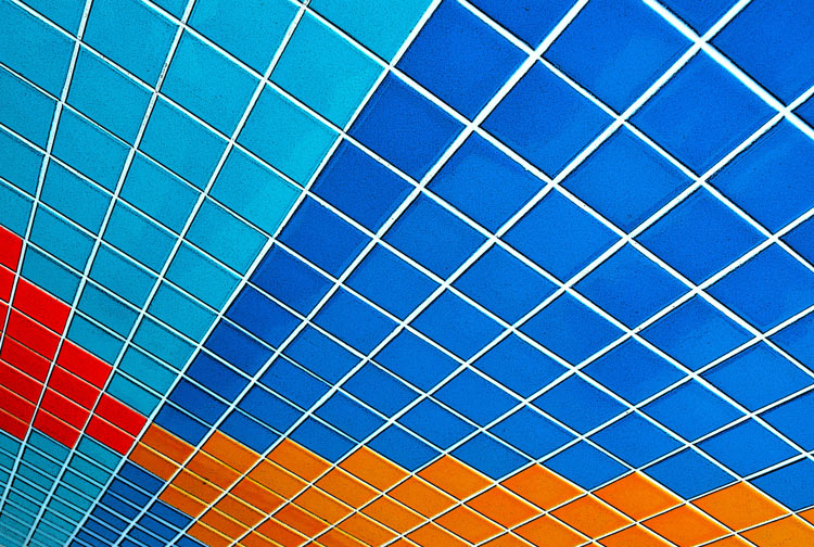 abstract looking picture of a wall covered in blue, turquoise, orange and red square tiles.  Photo taken so the tiles are on a diagonal.  Exterior of the Lula Lounge. 