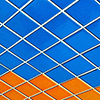 abstract looking picture of a wall covered in blue, turquoise, orange and red square tiles.  Photo taken so the tiles are on a diagonal.  Exterior of the Lula Lounge. 