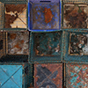 abstract looking picture of the ends of square bottomed trash cans piled against a wall for storage during the winter 