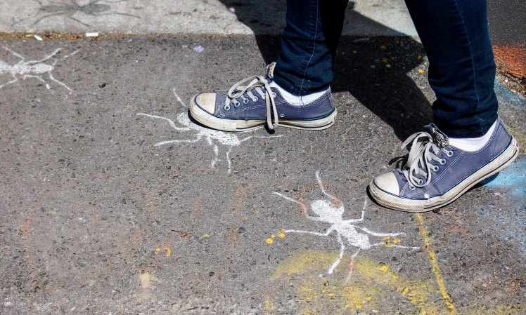 stomping on painted images of ants on the sidewalk