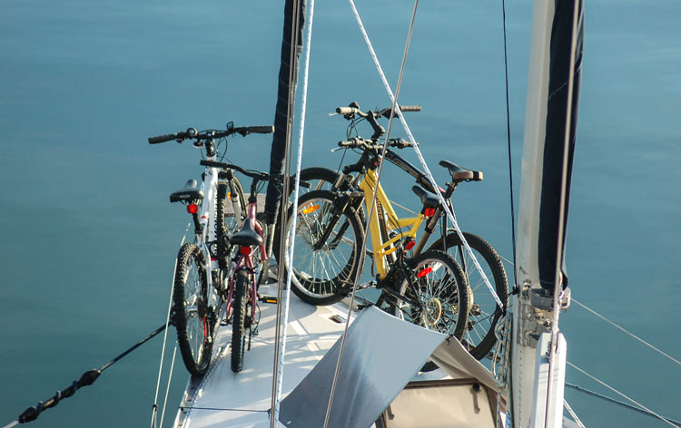 four bicycles tied to the rigging at the front of a sailboat 