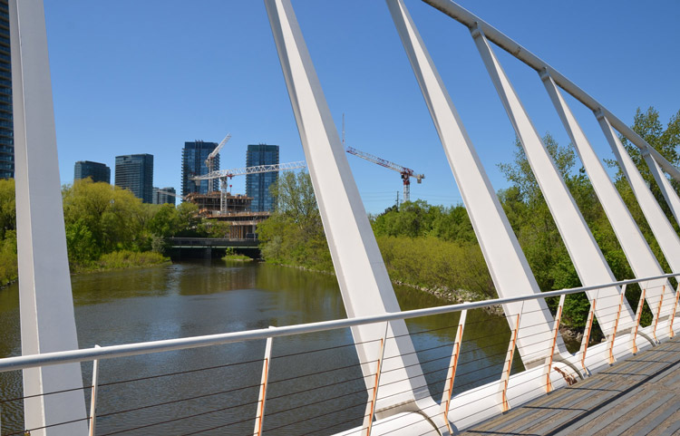 bridge over a creek at Humber Bay Park.  construction of a new condo in the background.  