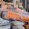 barrels of Asian food items for sale outside a store in Chinatown, including barrels of gingko biloba.  Most of the labels are in Chinese