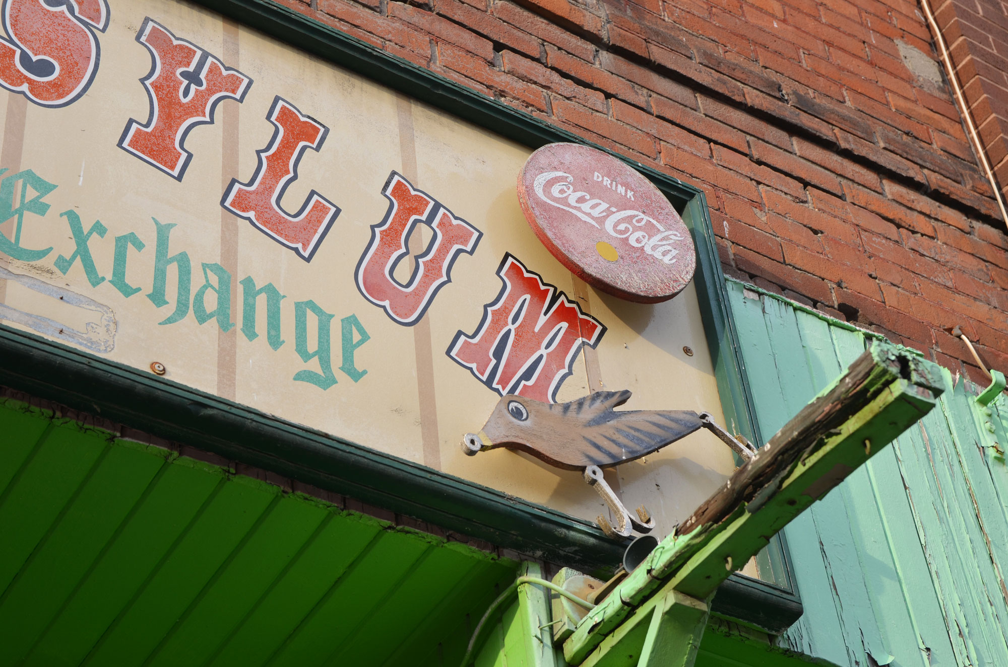 an old wooden coca cola sign on the front of a store