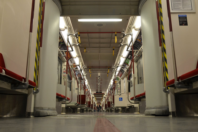 view from floor level of an empty new TTC subway car, looking down the length of the train.