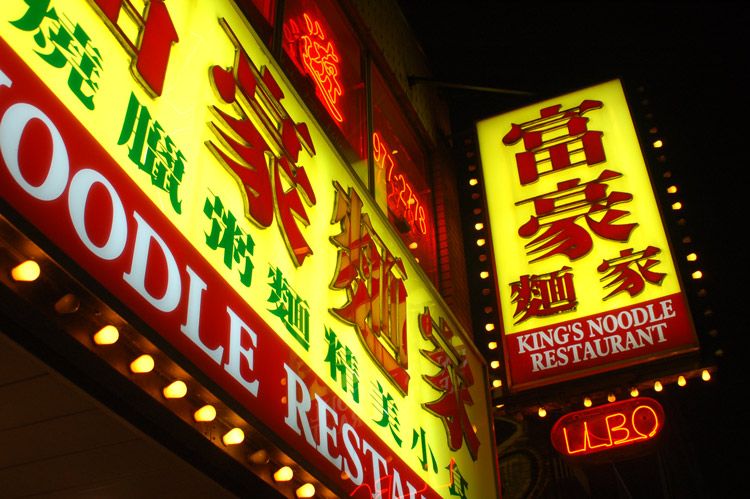 brightly lit exterior sign for Kings Noodle restaurant taken at night
