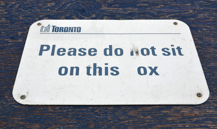 do not sit on this ox which should say box not ox. Someone has scratched off the letter b in box.
