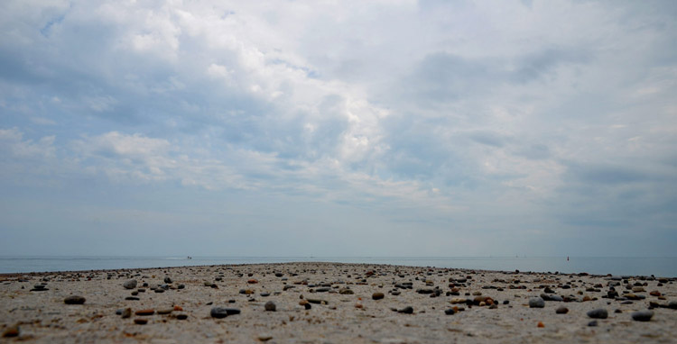 sand and pebbles, a photo taken from down low, lots of sky in the picture. 