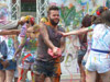 a man using a jug of red paint to try to spray other people 