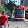 an older streetcar is traveling south and a new streetcar is coming north as they pass each other on Spadina at the intersection with Dundas.  