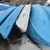 small blue boats stored upside down for the winter 